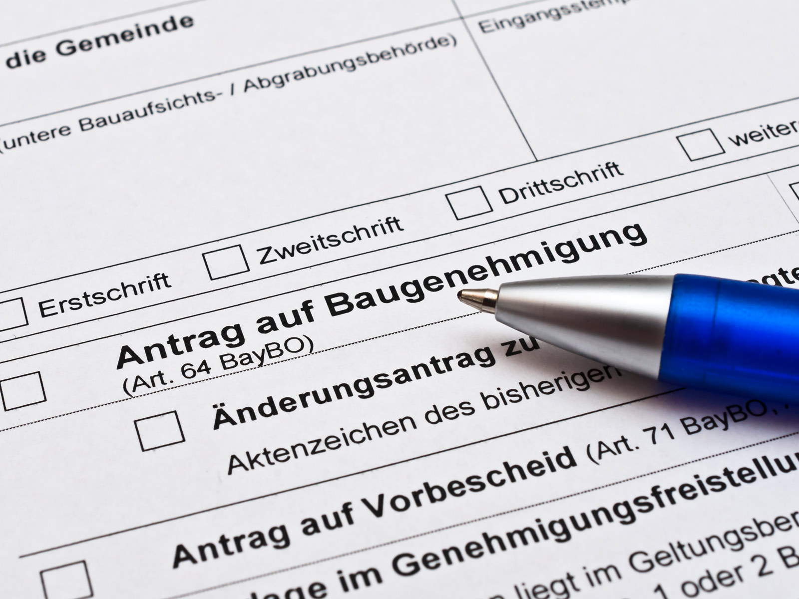 Kugelschreiber zeigt auf den text "Antrag auf Baugenehmigung".