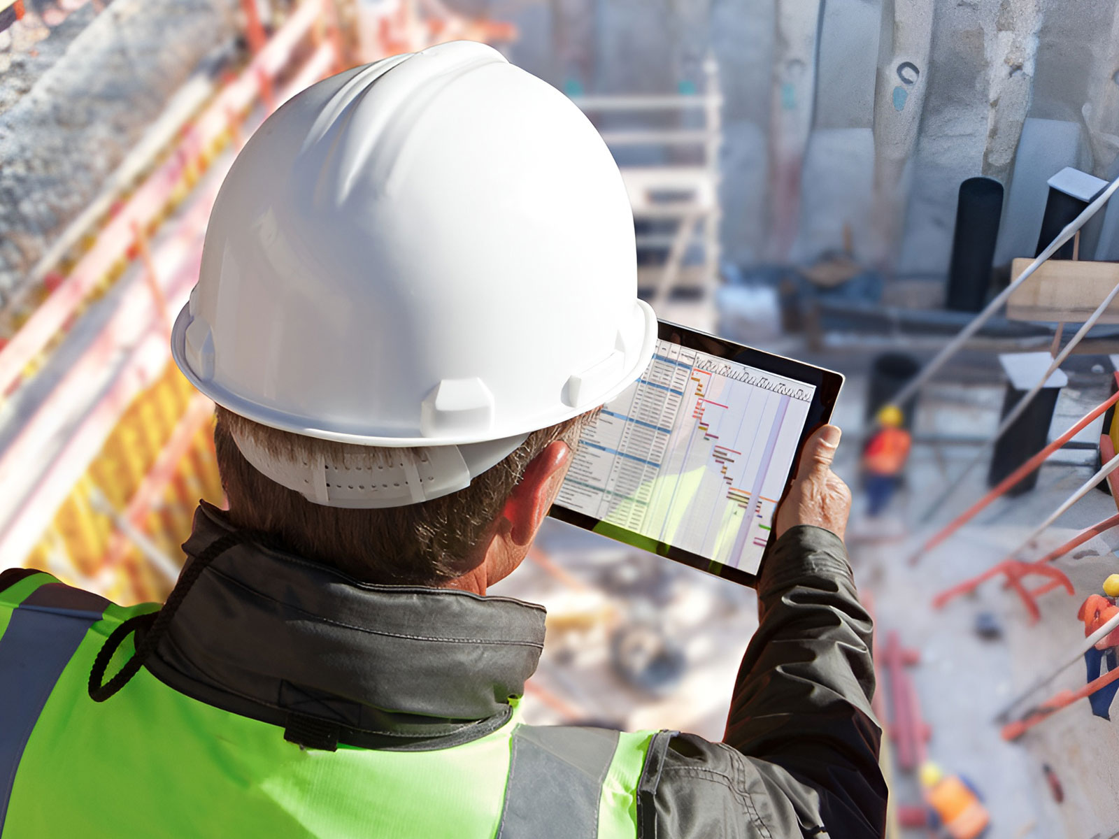 Ein Mitarbeiter von Assmann Beraten + Planen überprüft auf seinem Tablet den Fortschritt eines Bauprojekts