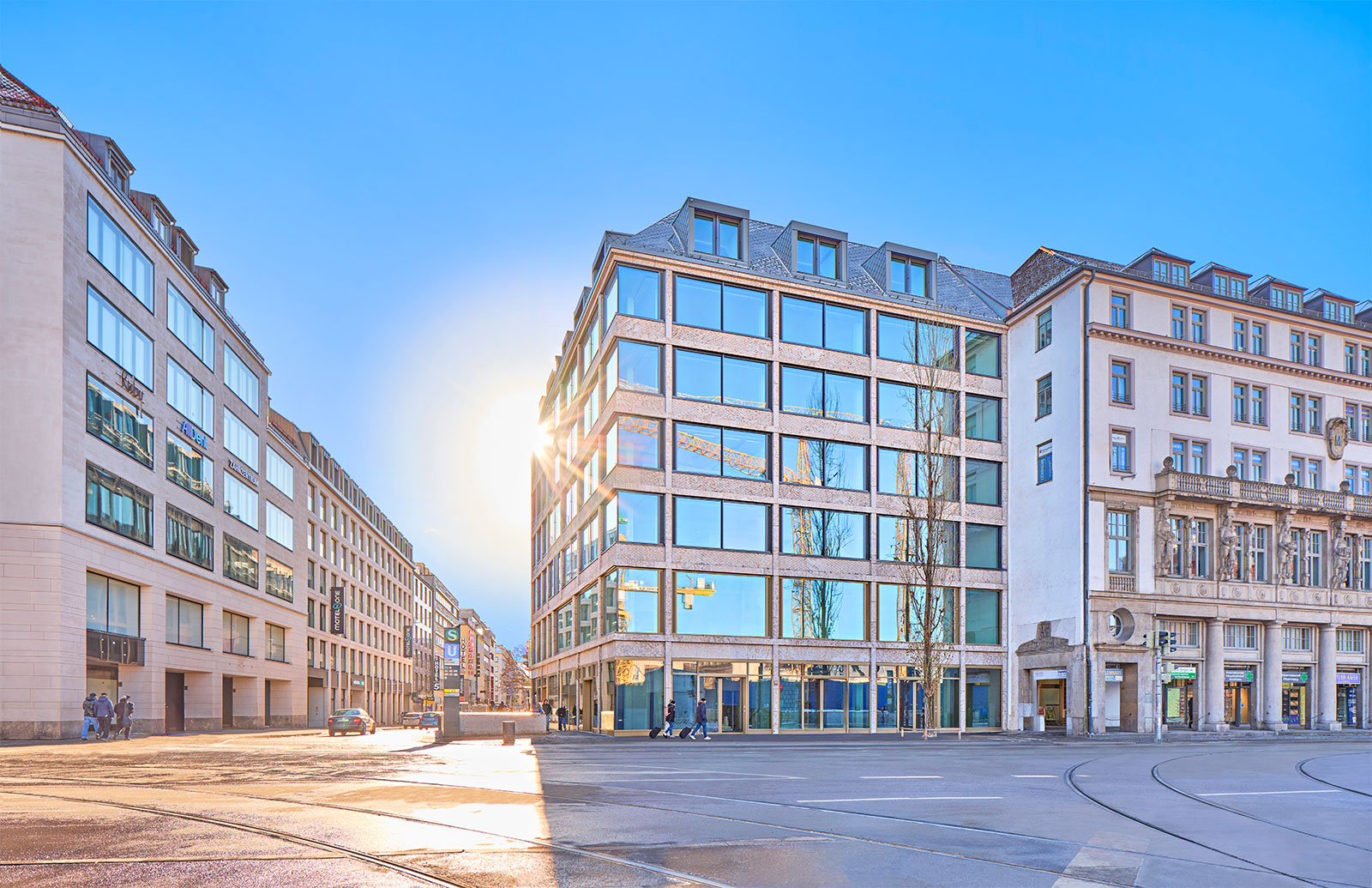 Fotografie des B.munich in der Bayerstr. 25 in München. Die Glasfassade spiegelt den blauben Himmel.