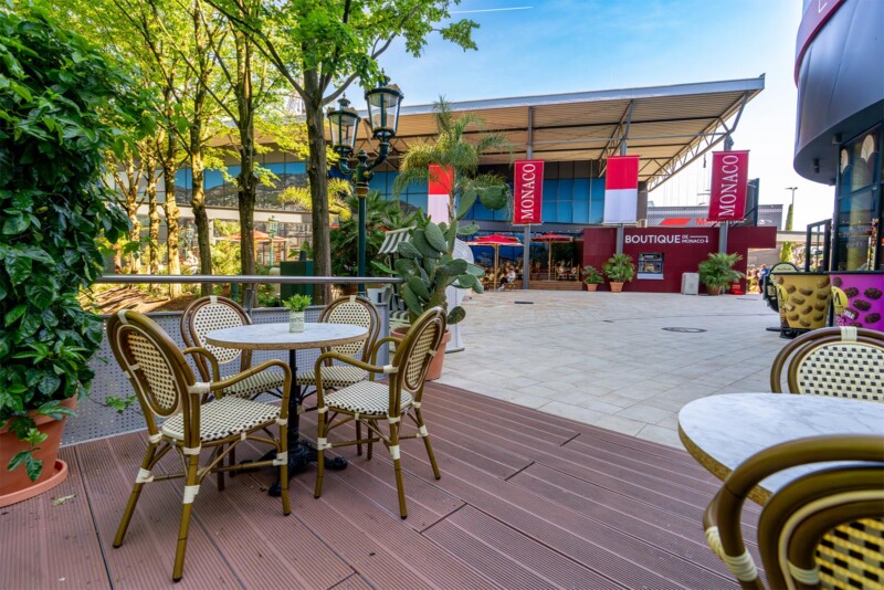 Gemütliche Café-Terrasse mit Rattanstühlen und Blick auf die Boutique de Monaco im Europa-Park Monaco