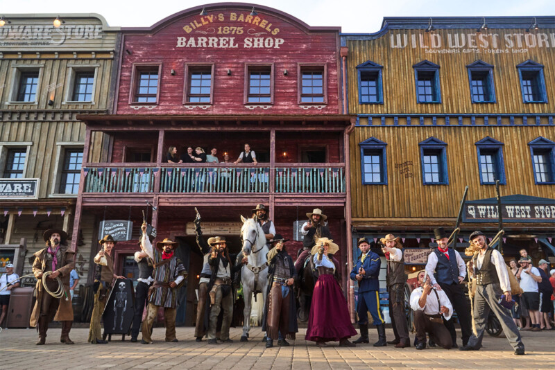 Cowboy-Darsteller posieren mit Pferden vor der Kulisse des Barrel Shop in Silver Lake City