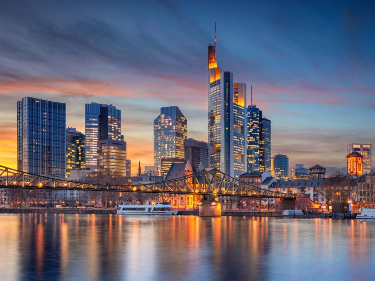 Das Bild zum Beitrag der World Design Capital 2026 zeigt die Frankfurter Skyline bei Sonnenuntergang. Die Stadt speigelt sich im Main.