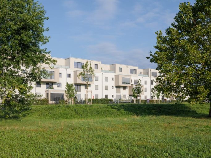 Baufeld C4 des neuen Stadtteils Mannheim Franklin: Moderne, vierstöckige, aneinander grenzende Mehrfamilienhäuser werden von Wiese und Bäumen umrahmt.