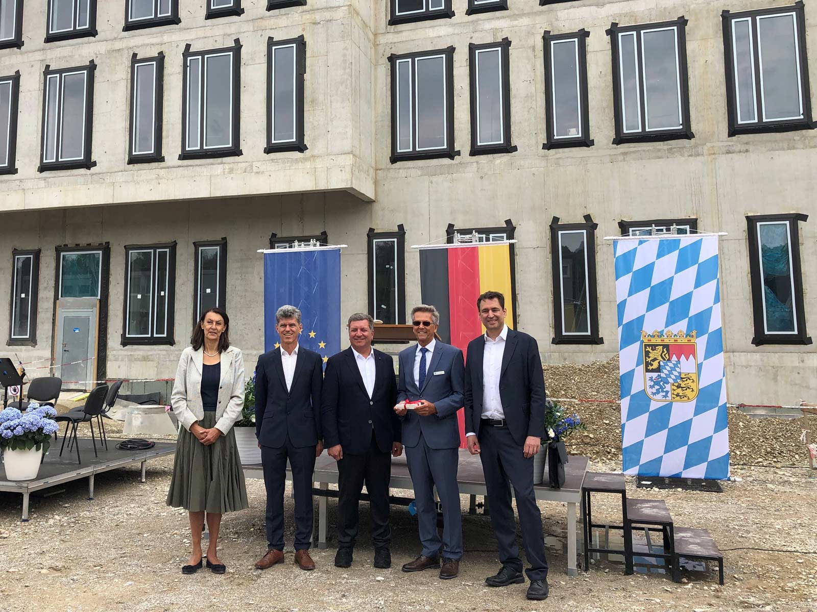 Neubau der Krankenabteilung für die Justizvollzugsanstalt (JVA) München: Das unfertige Gebäude im Hintergrund; Minister und Beteiligte im Vordergrund.