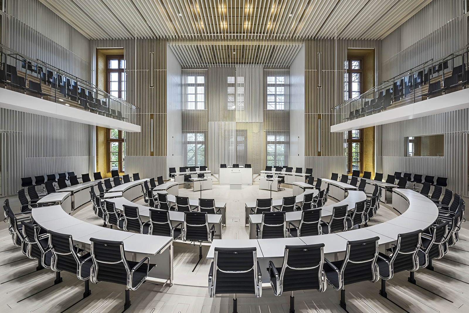 Konferenzraum mit oval angeordneten Tischen und Stühlen und Empore