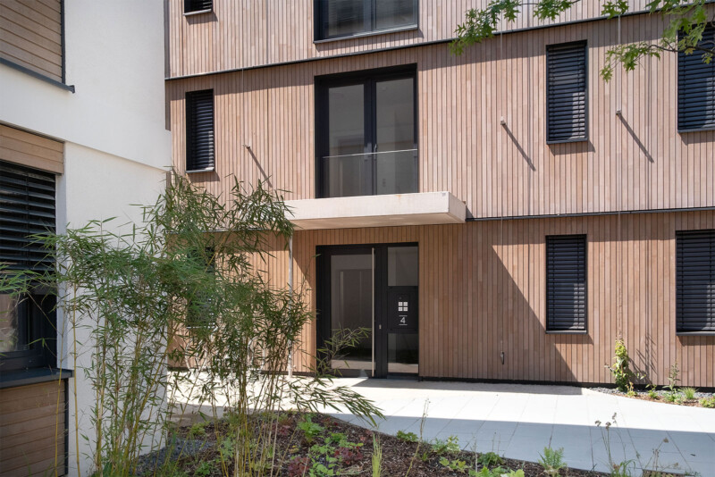 Hauseingang mit Holzfassade und Balkon