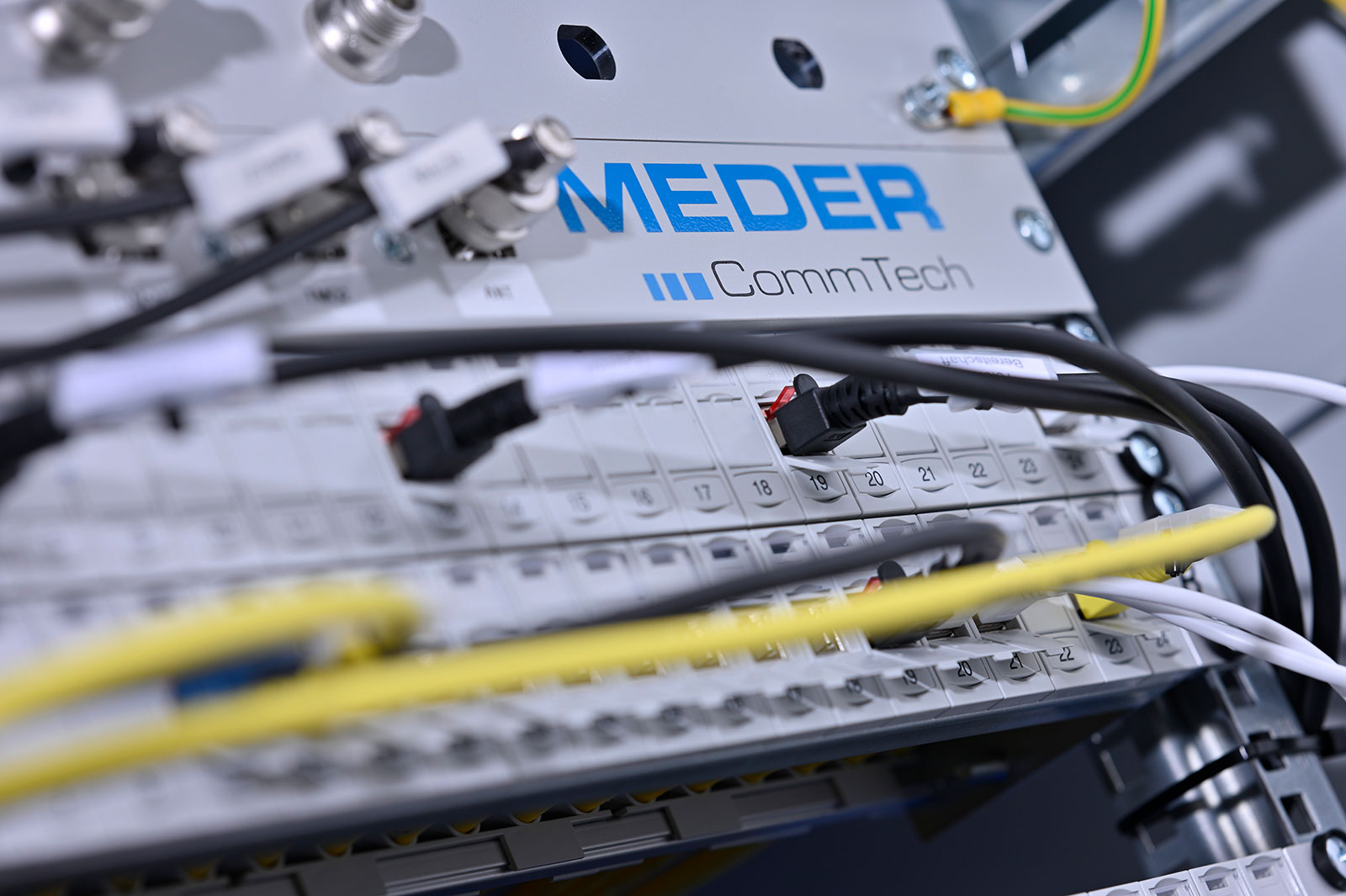 Profilbild der MEDER CommTech GmbH in Singen: Zu sehen ist ein Steckfeld mit mehreren Kabeln.