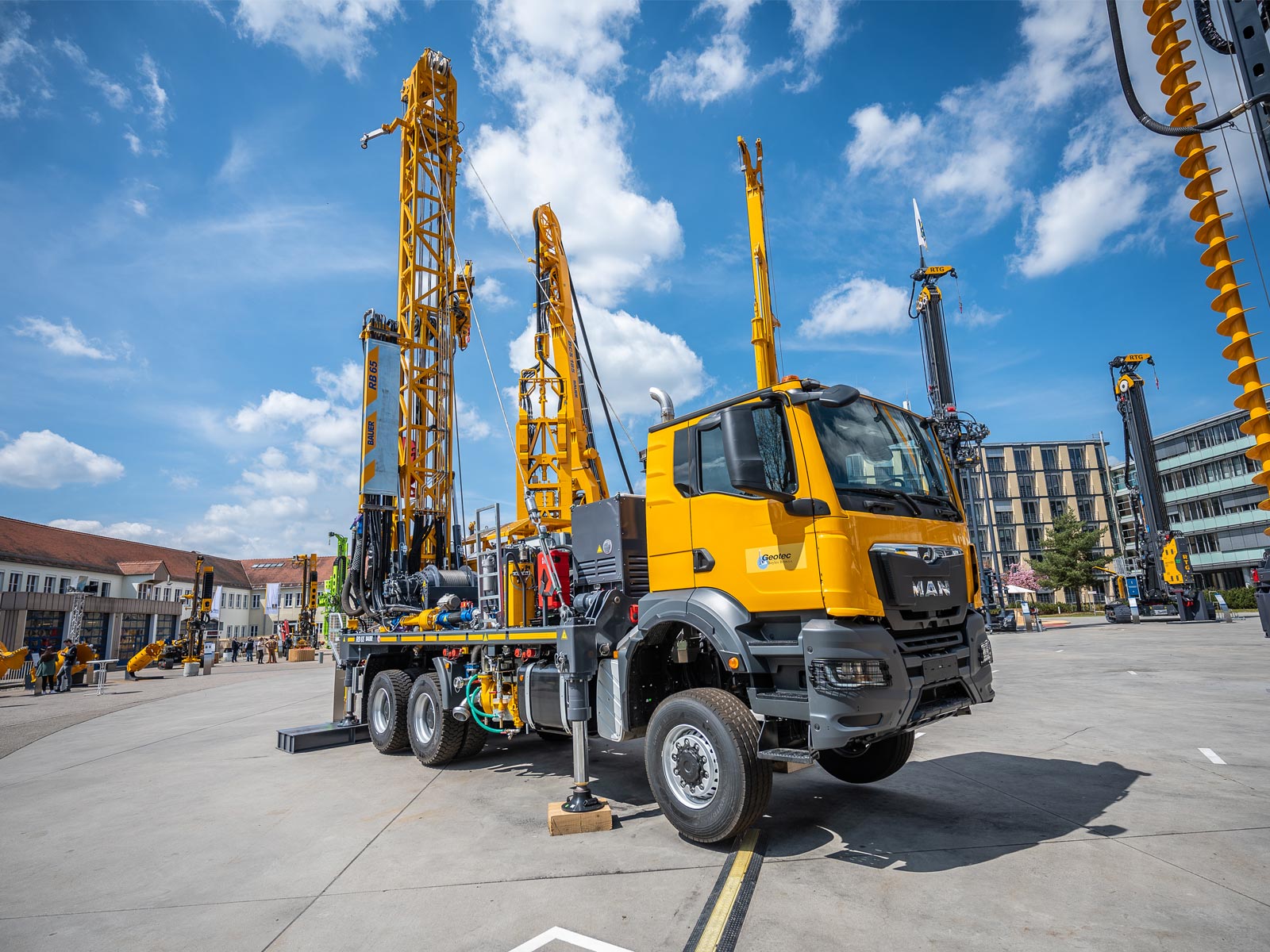 Mobile Bohranlage von BAUER vor blauem, leicht bewölktem Himmel.