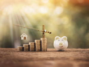 Ein Sparschwein, Geld und ein Baukran symbolisieren die soziale Wohnraumförderung des Bundes im Rahmen von Darlehen.
