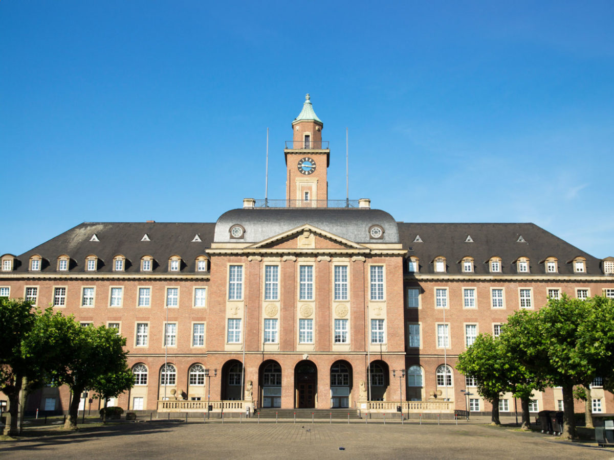 Beitragsbild zur Entwicklung des Ruhrgebietes: Das Rathaus Herne. Altes Gebäude mit roter Klinkerfassade und dunklem Spitzdach.