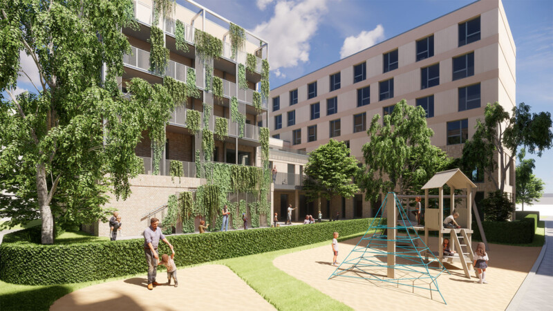 Begrünte Fassade mit Rankpflanzen und Innenhof mit Spielplatz, Kletternetz und Spielturm zwischen Wohngebäuden