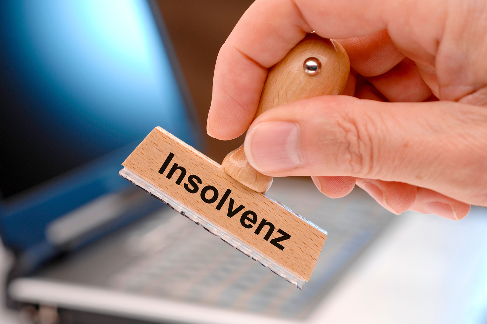 Eine Hand hält einen Stempel mit der Aufschrift "Insolvenz" ins Bild. Es verbildlicht die aktuelle Lage der Tecklenburg GmbH, die einen Antrag auf Eröffnung eines Insolvenzverfahrens gestellt hat.