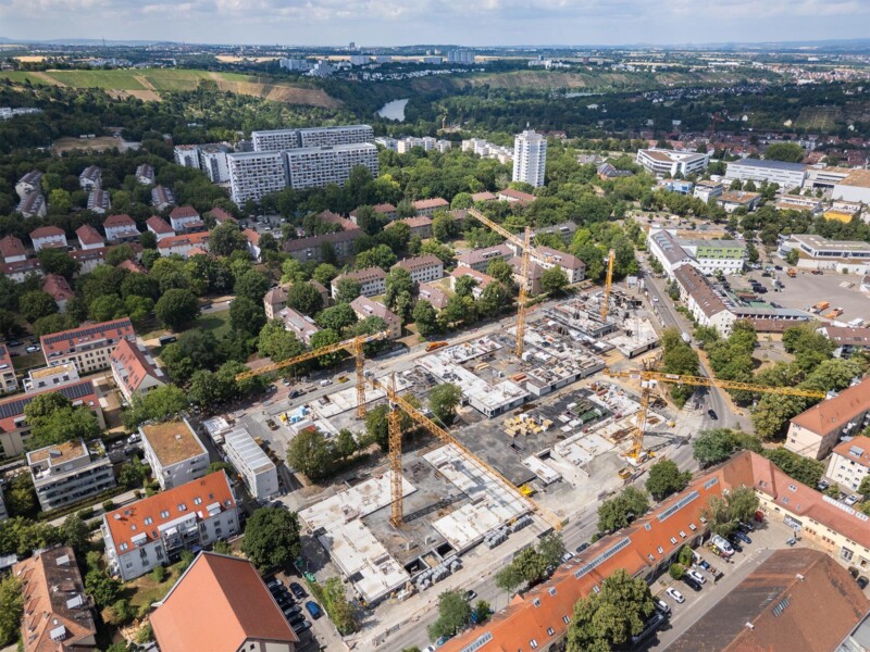 Wohnhöfe am Römerkastell: Baustelle mit Kränen im Rohbaustadium, umgeben von bestehender Wohnbebauung